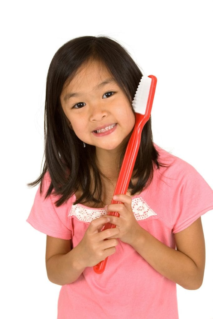 a girl holding a giant toothbrush