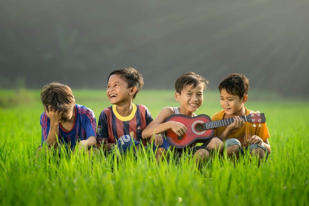 4 boys sitting on the grass