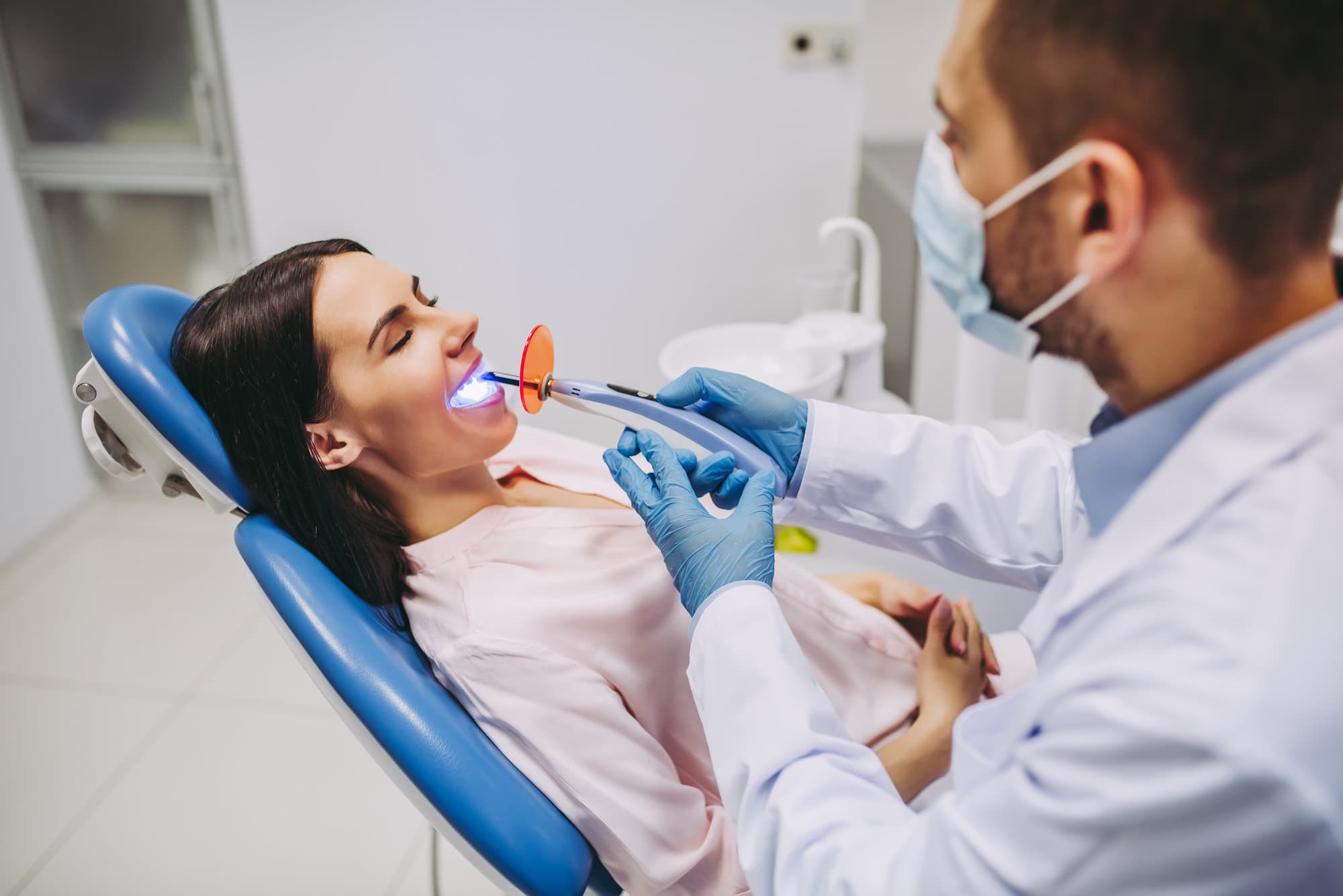 male dentist using UV lamp for crowning