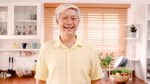 Old man getting used to dentures smiling