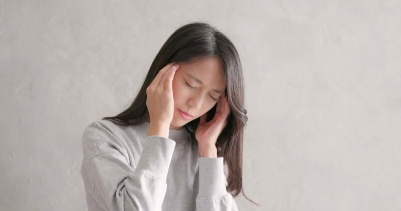 woman having a headache from teeth grinding