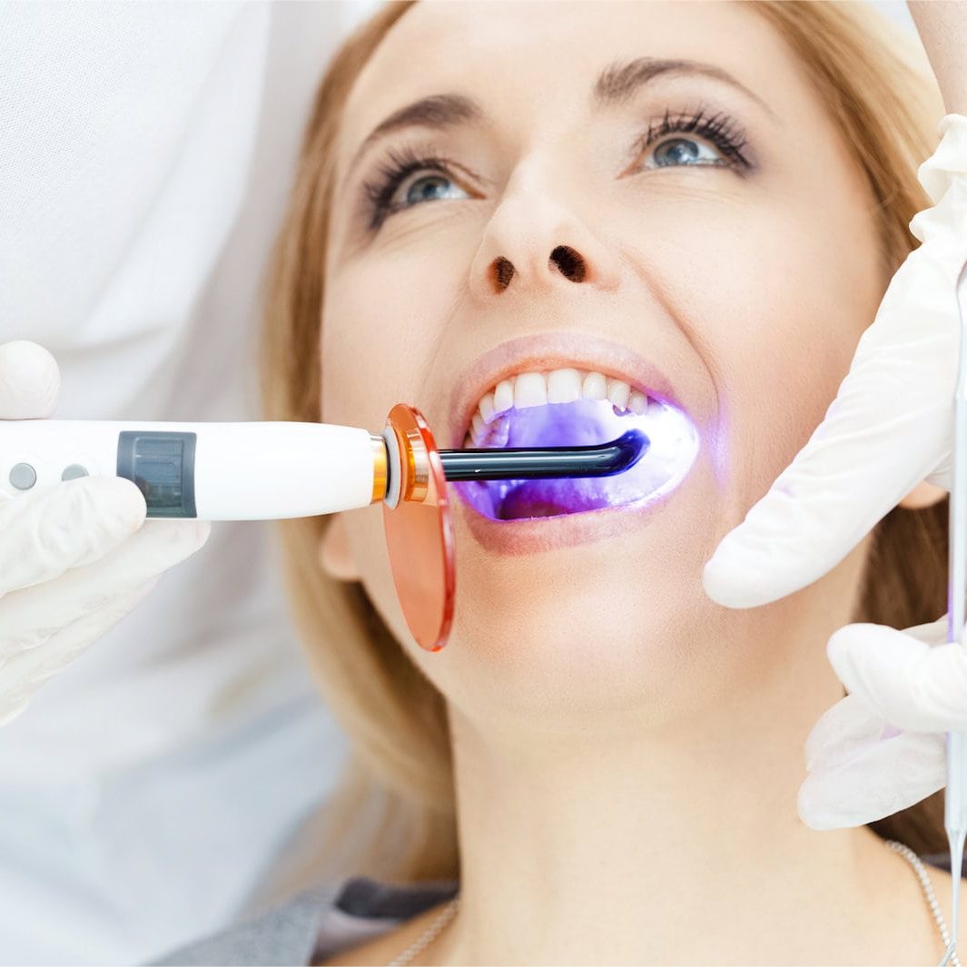 woman having UV treatment for her teeth